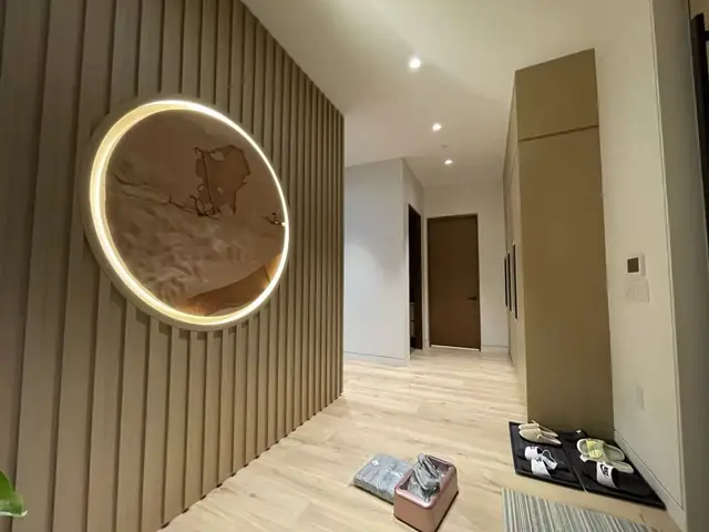 Fluted wood feature wall with a backlit circular art piece