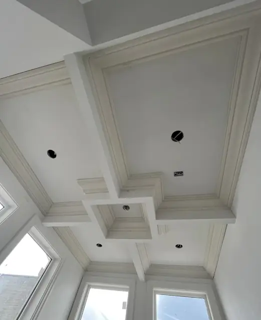 Coffered ceiling with cross-beam detail above bay windows