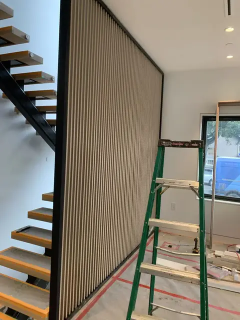 Floor-to-ceiling slat screen beside an open-riser staircase