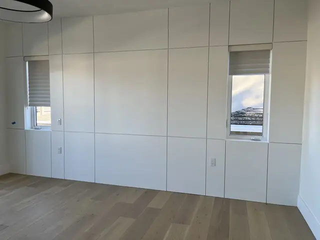 Seamless flat-panel wall cabinetry with concealed doors
